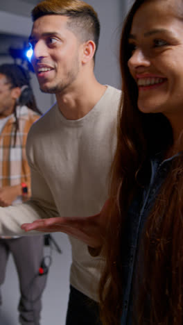 Vertical-Video-Of-Film-Crew-And-Female-Director-Congratulating-Actors-After-Performance-Shooting-Movie-In-Studio-Shot-In-Real-Time-1